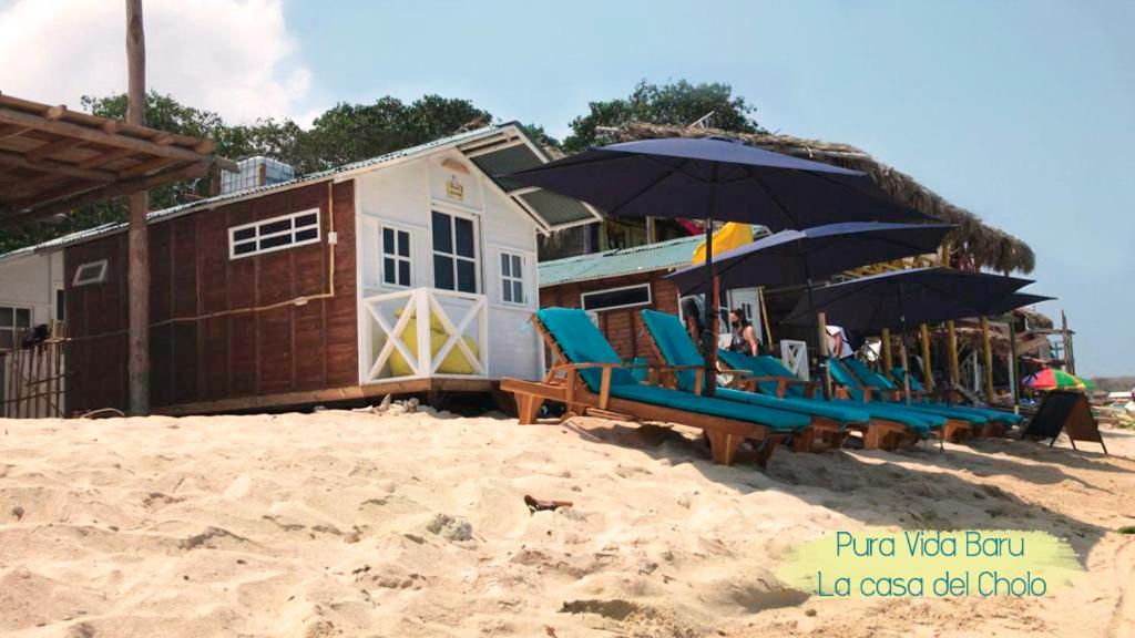 巴尔Pura Vida Baru - La Casa del Cholo的海滩上的一组椅子和遮阳伞