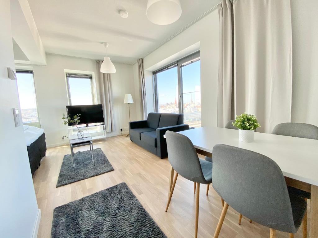 坦佩雷City Home Finland Studio Suite - Great City Views and Perfect Location next to Railway Station的客厅配有桌椅和沙发