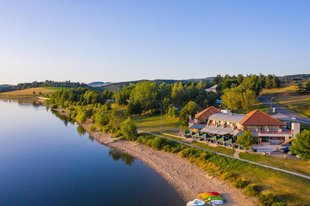 朗戈涅Les Lofts du Grand Lac de Lozère的享有河流的空中景致,设有度假村