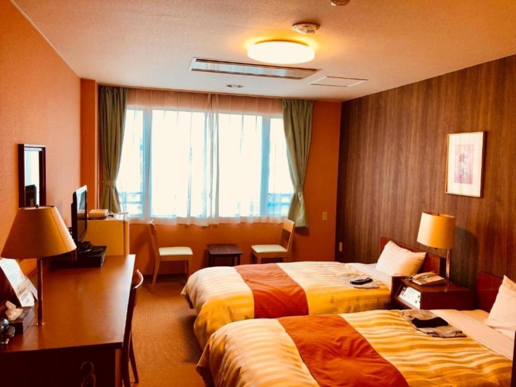 富士市Fuji Green Hotel - Vacation STAY 18934v的酒店客房设有两张床和窗户。
