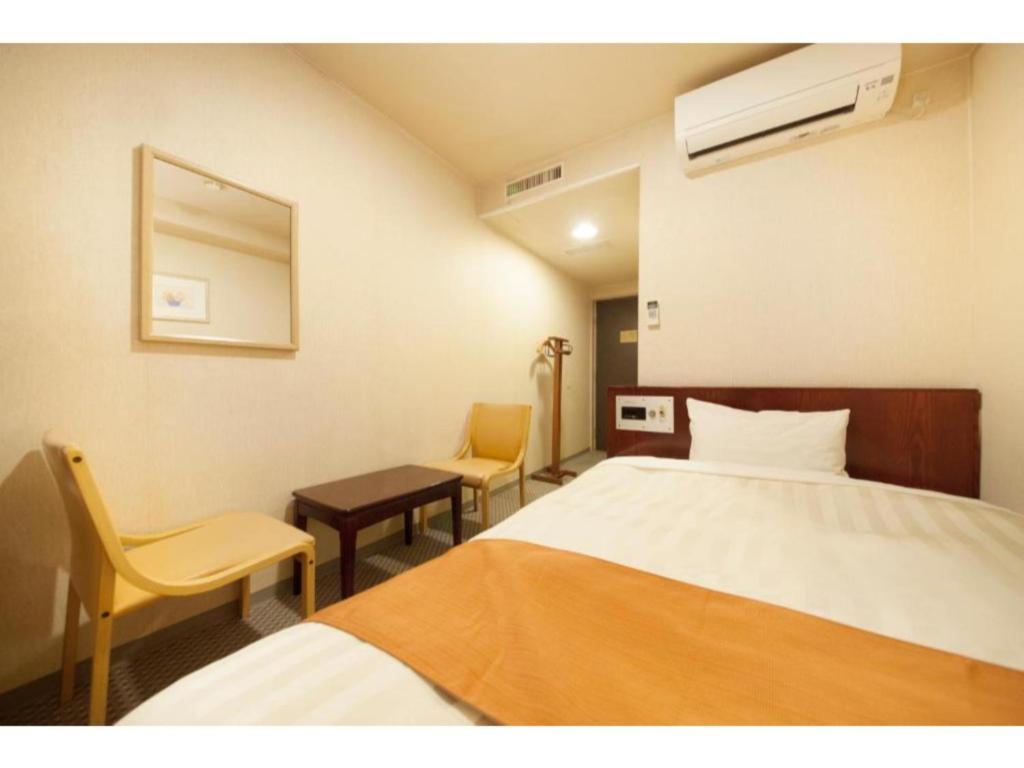 富士宫市Fujinomiya Green Hotel - Vacation STAY 19011v的酒店客房,配有一张床和两把椅子