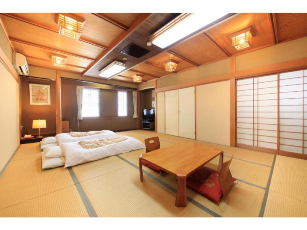 富士宫市Fujinomiya Green Hotel - Vacation STAY 19035v的一间设有床铺和桌子的房间