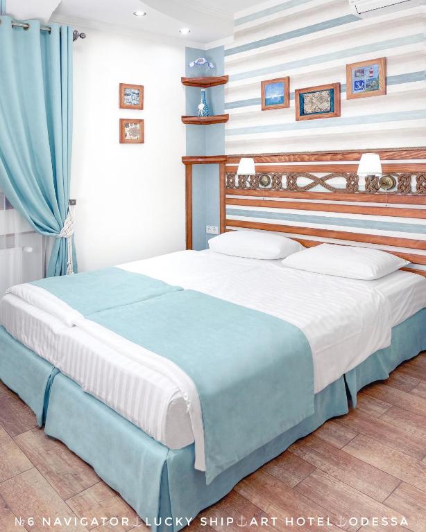 敖德萨Lucky Ship Art Hotel的一间卧室配有一张蓝色和白色条纹的大床