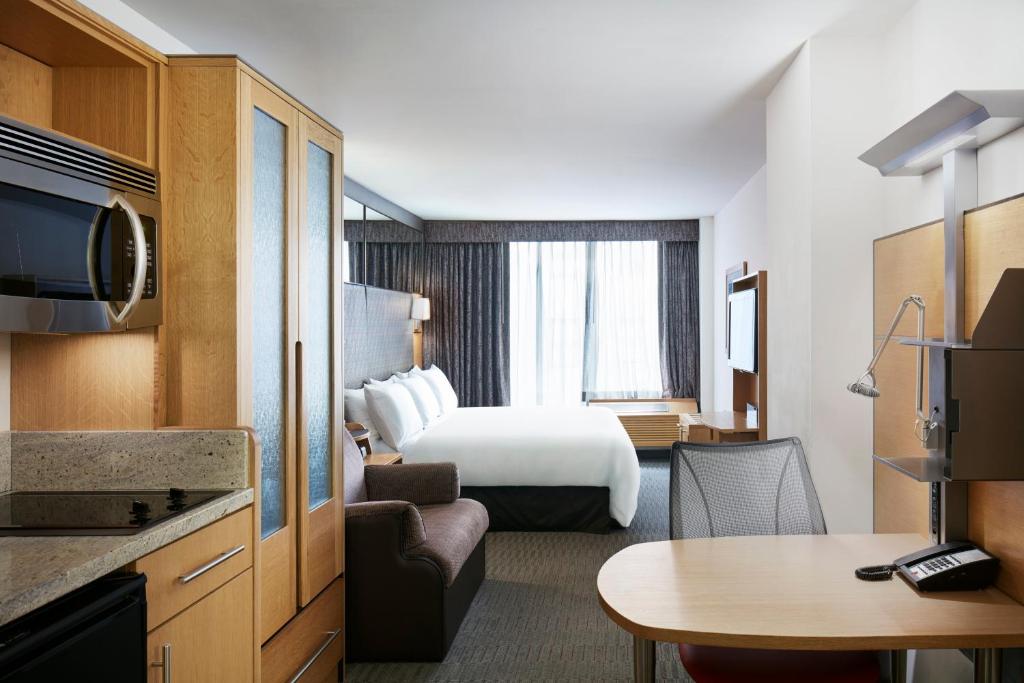 纽约The Jewel Hotel, New York的酒店客房配有一张床铺和一张桌子。