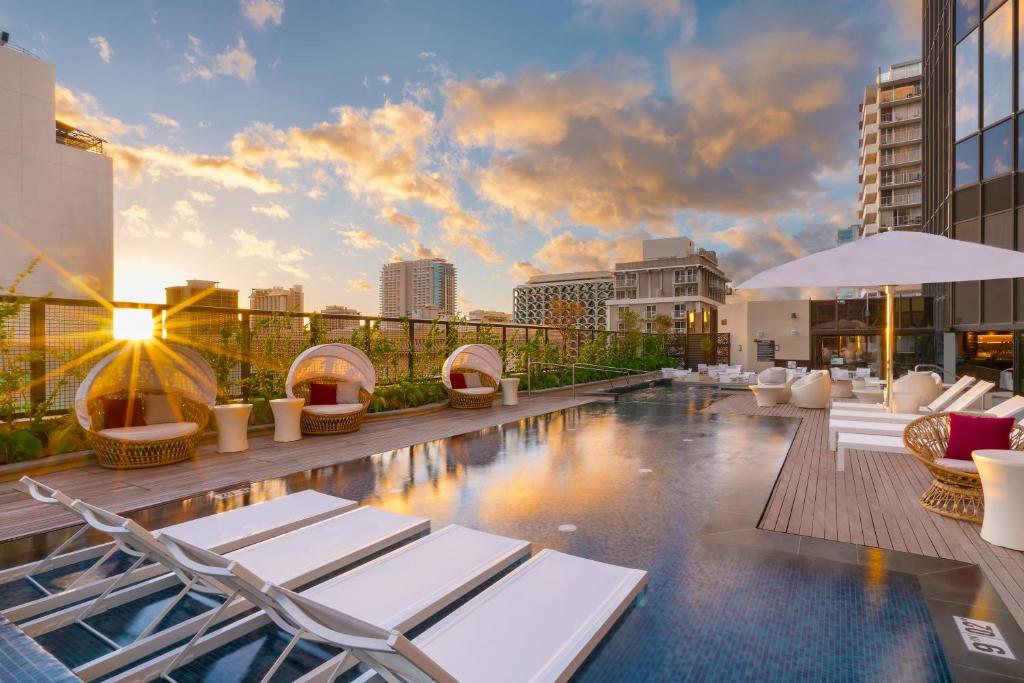 檀香山怀基基海滩凯悦中心酒店的一座带躺椅的建筑屋顶上的游泳池