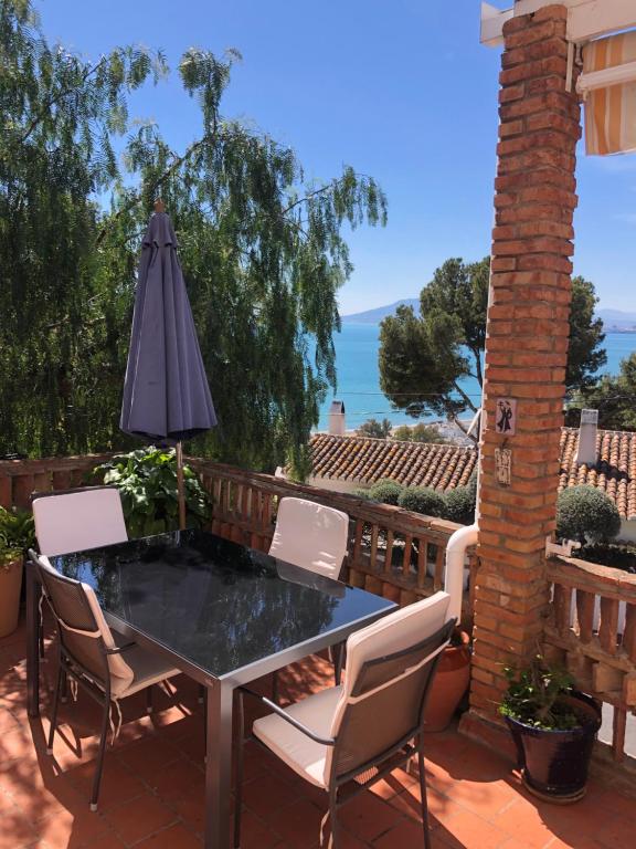 马拉加A home-from-home with stunning views fibre-optic broadband + UK and Spanish TV的庭院配有桌椅和遮阳伞。