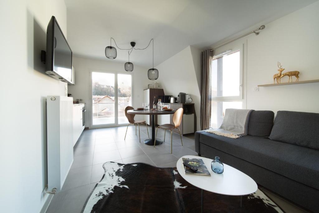 艾克斯莱班LES MYRTILLES Aix les Bains的客厅配有沙发和桌子