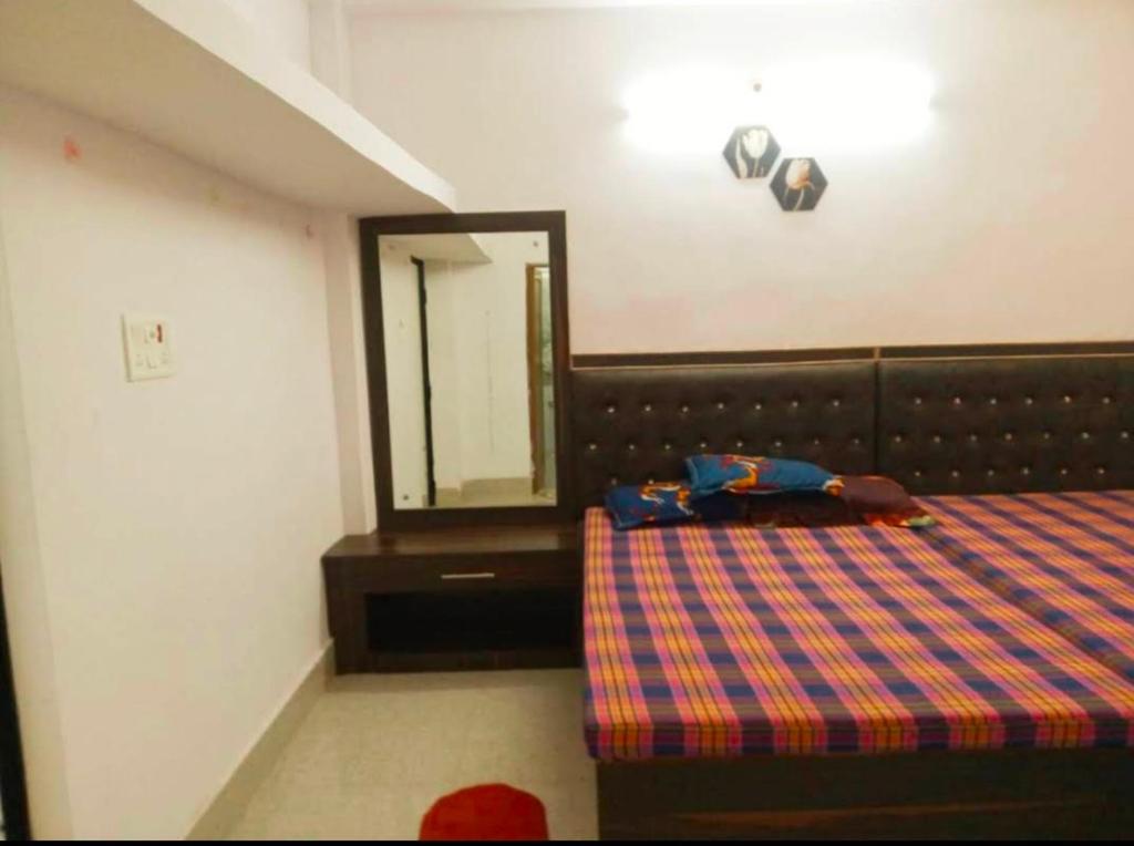 德奥加尔CHINTA HARAN REST HOUSE的一间卧室配有一张床和镜子
