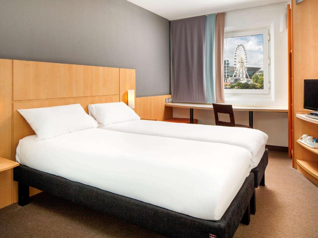 格雷斯瑟罗克伦敦瑟罗克M25宜必思酒店的一间卧室设有一张大床和一个窗户。