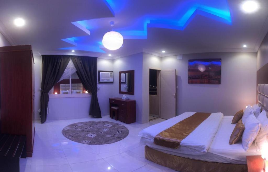 巴勒如拉斯Al Tal Serviced Apartments的一间卧室配有一张蓝色天花板的床