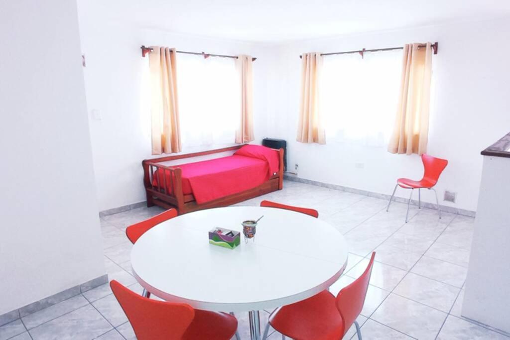 埃尔卡拉法特Newen的客厅配有白色桌子和红色椅子