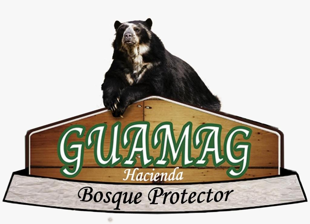 巴尼奥斯Bosque Protector Hacienda Guamag的坐在标志上的一个熊