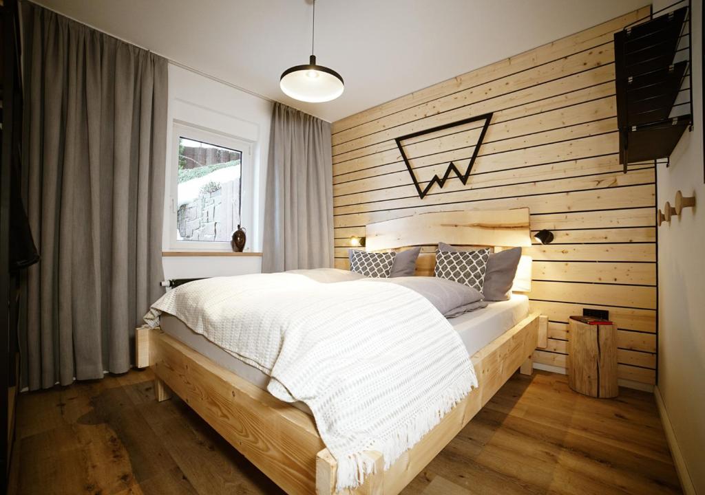 奥泊维森塔尔Chalet Hans的一间卧室配有一张木墙床