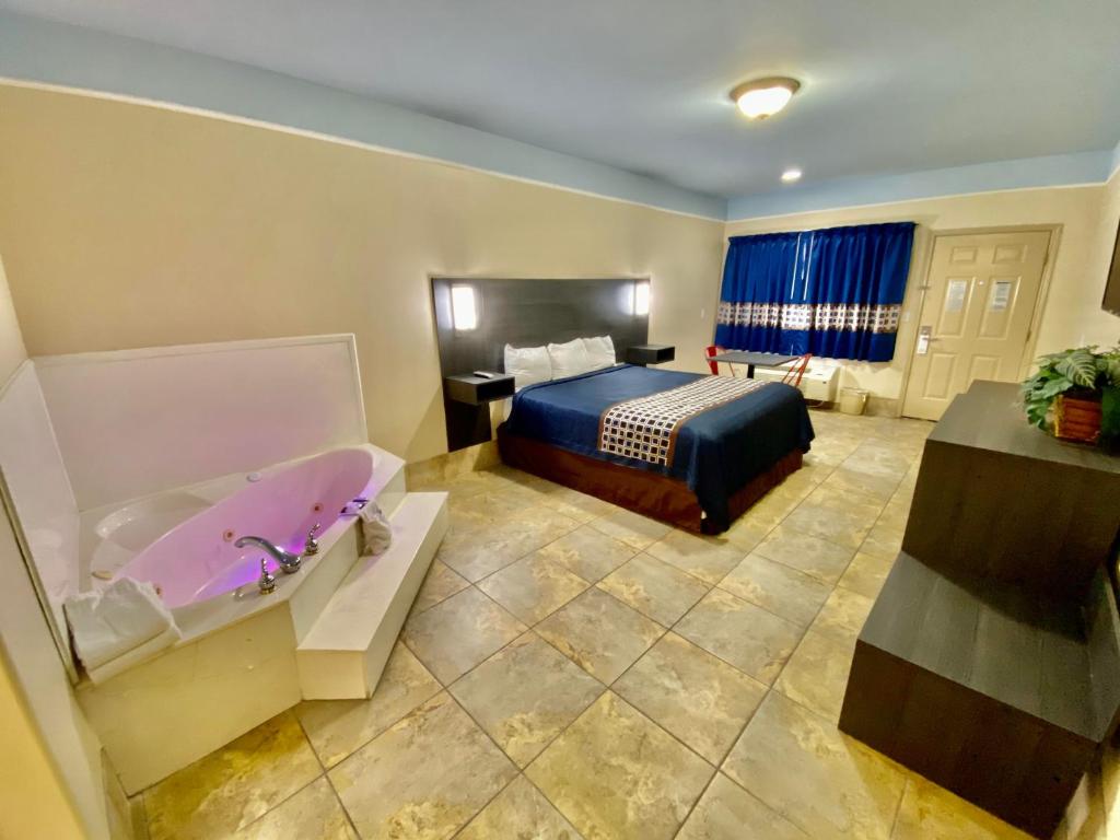 麦卡伦Texas Inn & Suites McAllen at La Plaza Mall and Airport的酒店客房配有一张床和浴缸。