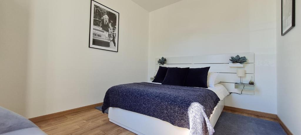 博讷Chez Charles Centre-Parking privé-Hospices-Gare的一间卧室配有一张白色的床和蓝色的毯子