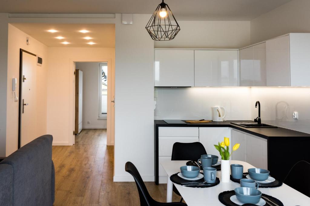 韦巴Apartamenty DIAGO的厨房以及带桌椅的起居室。