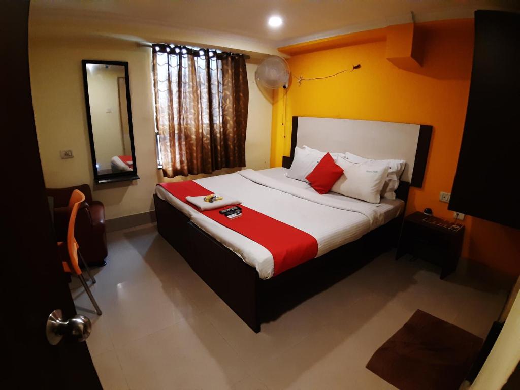 钦奈Hotel Akash inn的一间卧室配有红色和白色枕头的床