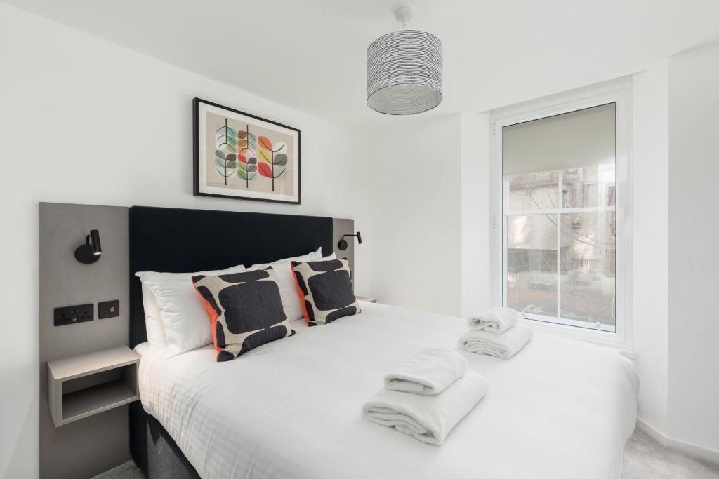 爱丁堡Destiny Scotland Market Street Apartments的白色卧室配有一张大床和毛巾
