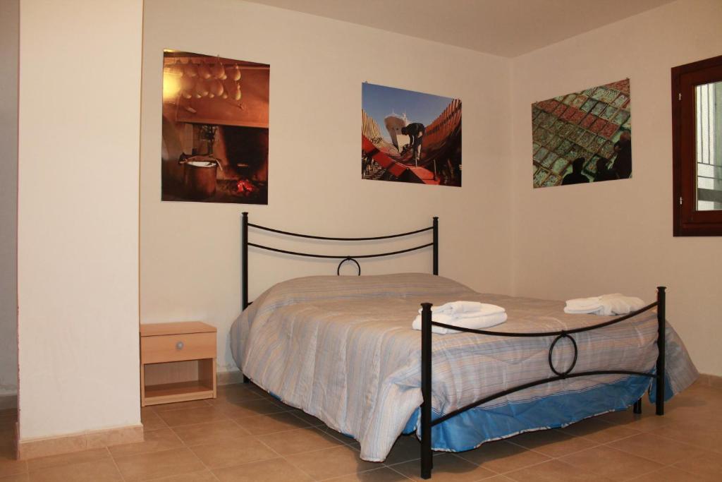 曼弗雷多尼亚索尔门公寓酒店 的卧室配有一张床,墙上挂有两张照片