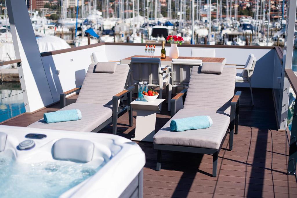 波尔托罗Adria Portorož Luxury Houseboat的阳台配有躺椅和热水浴池。