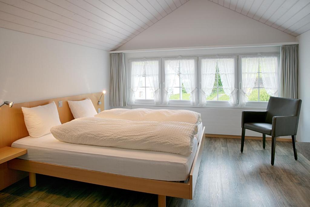 韦斯巴德Loosmühle的一间卧室配有一张床、一把椅子和窗户。