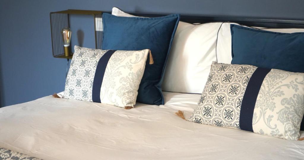 里米尼LaMalatestina Suite - Apartment in front of the Castle的一张带蓝色和白色枕头的床