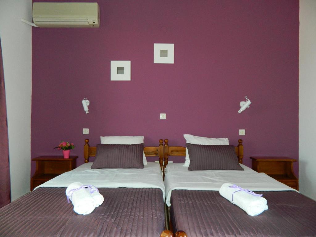法里拉基罗斯伯里公寓酒店的一间卧室配有一张紫色墙壁的床