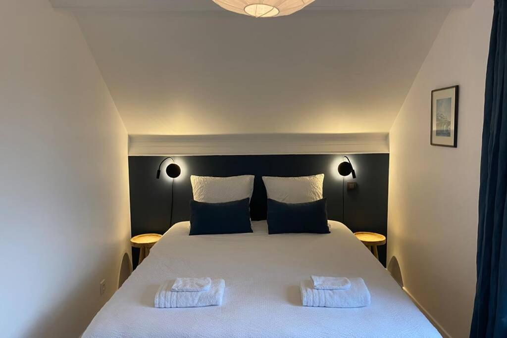 那慕尔Gîte le 44 - au calme avec jardin, proche de Namur的卧室配有一张带两个枕头的大白色床