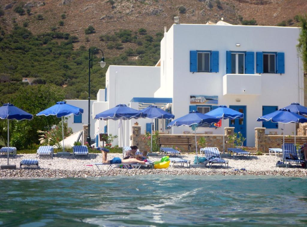 里瓦的亚梦之岛公寓式酒店的海滩上的人,有蓝色的遮阳伞和水