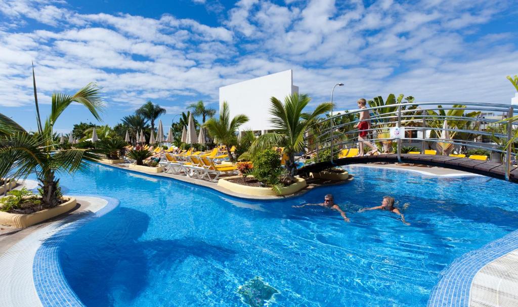 洛斯克里斯蒂亚诺斯天堂公园趣味时尚酒店的度假村的游泳池,人们在里面游泳