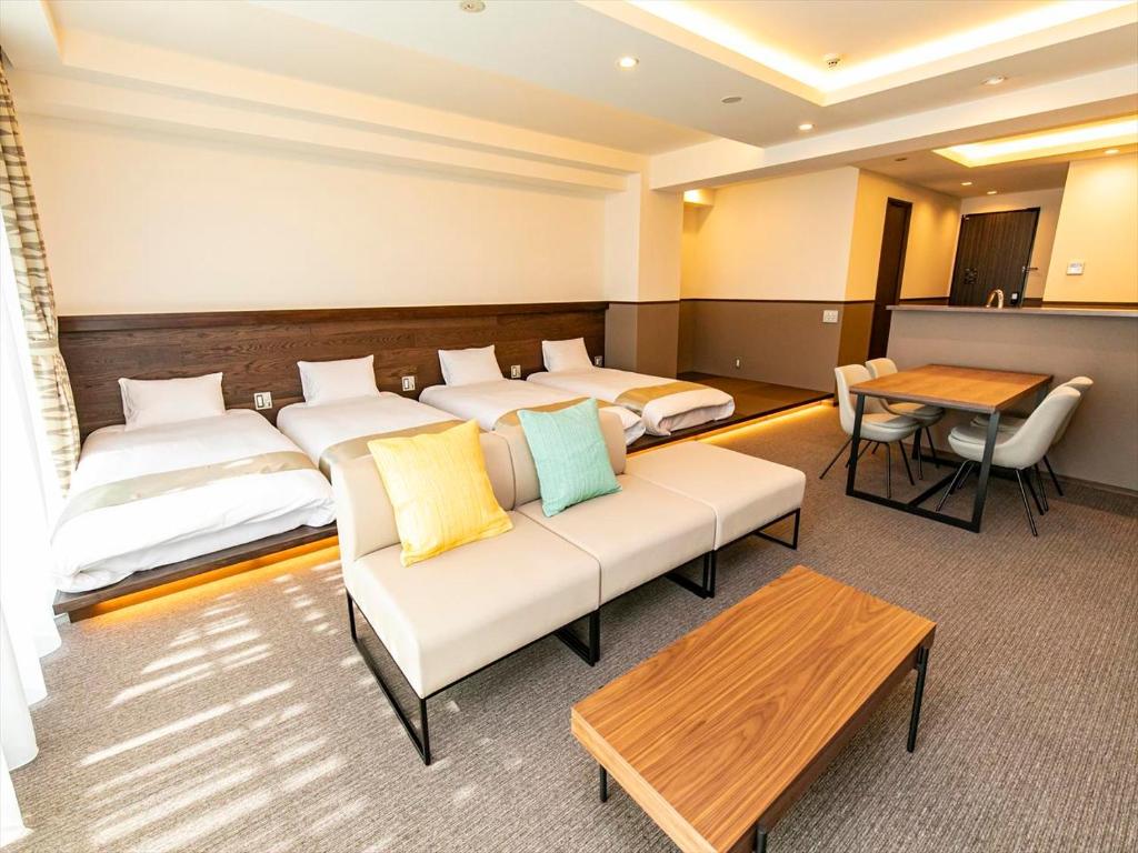 东京Minn Asakusa的客房设有两张床、一张沙发和一张桌子。