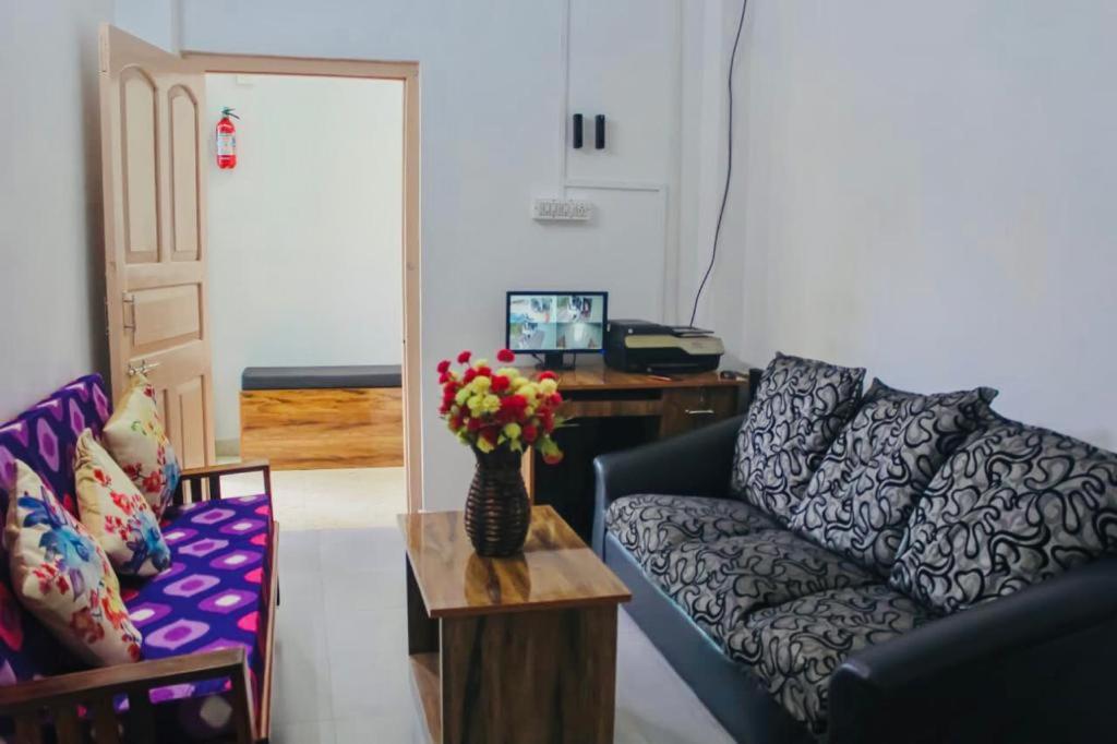 布莱尔港Zcube Andaman的客厅配有沙发和鲜花桌