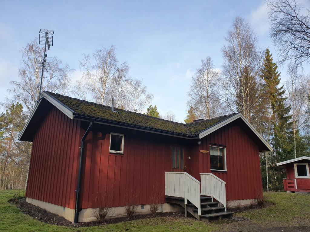 HargSjöstuga Vätö的田野上带楼梯的红色谷仓
