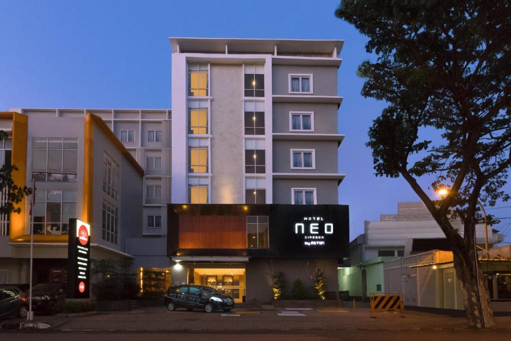 井里汶Hotel NEO Cirebon by ASTON的前面有停车位的建筑