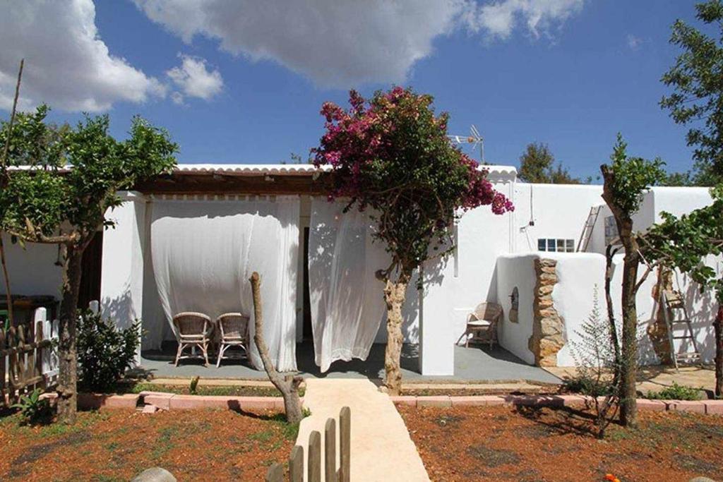 圣卡洛斯Agroturismo Casa Morna Ibiza的院子内带桌椅的白色房屋