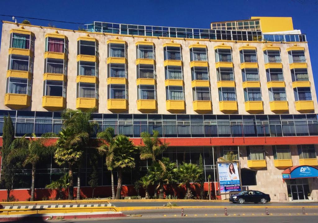 萨卡特卡斯Hotel Arroyo de la Plata的城市街道上一座带黄色窗户的办公楼