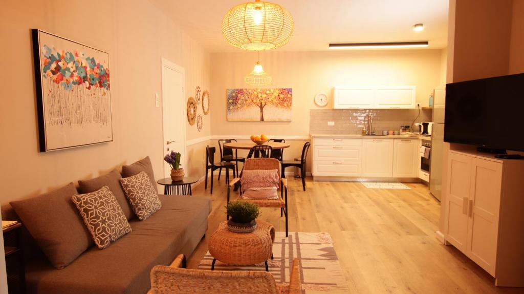 兹奇隆亚科夫Cute & Cozy House in Zichron Yaakov的带沙发和桌子的客厅以及厨房。