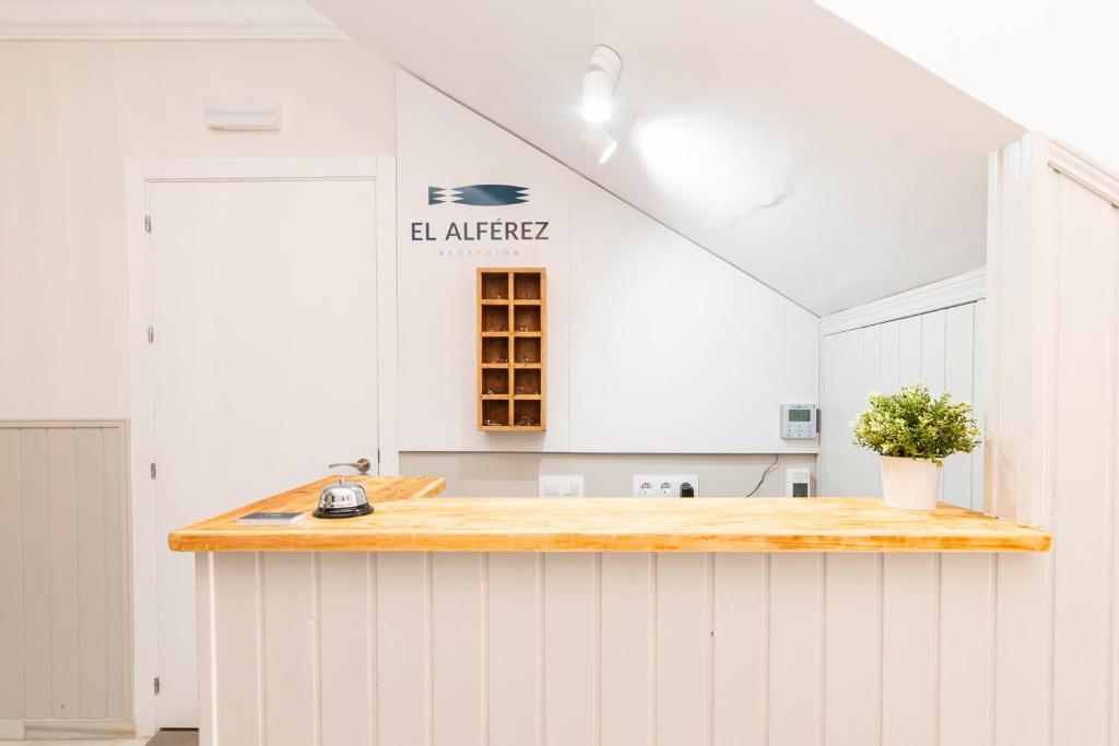埃尔帕尔马Hostal El Alférez的厨房配有白色橱柜和木制台面