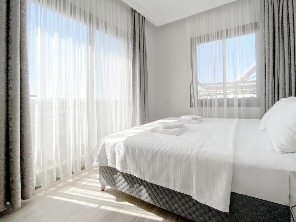 伊兹密尔Azize Palas Apart Otel的白色的卧室设有床和大窗户