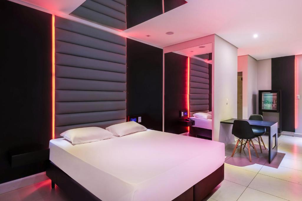 索罗卡巴Plaza Motel的卧室配有一张白色大床和一张书桌