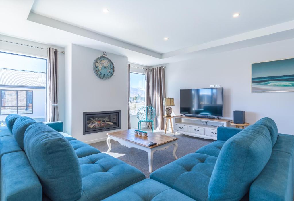 特卡波湖Neptune - Lake Tekapo的客厅配有蓝色的沙发和电视