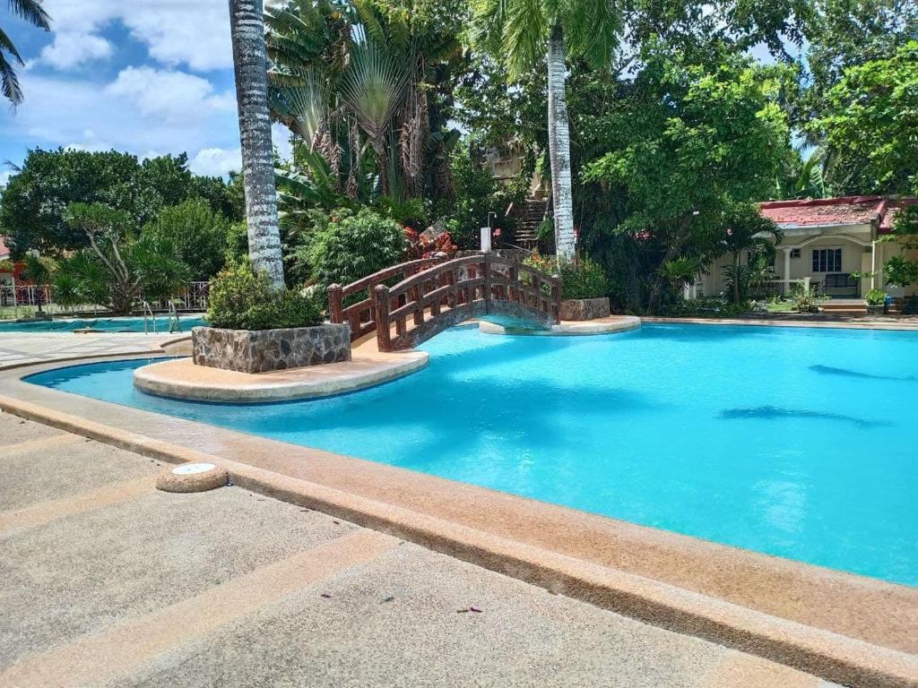 宿务RedDoorz Plus @ Costa Roca Balamban的一座蓝色的大型游泳池,四周环绕着木栅栏