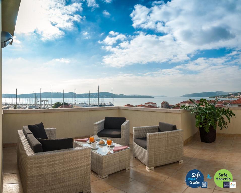 特罗吉尔罗通多酒店的阳台配有桌椅,享有海景。