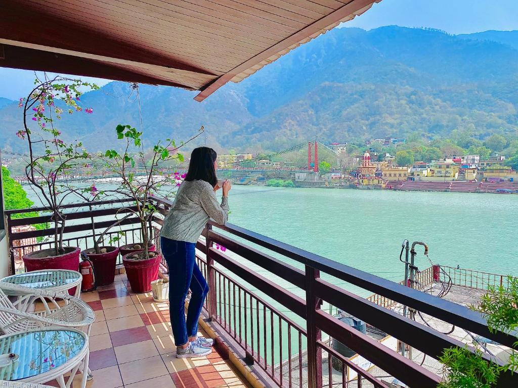 瑞诗凯诗圣斯奎提吠陀度假酒店的站在一个水景阳台上的女人