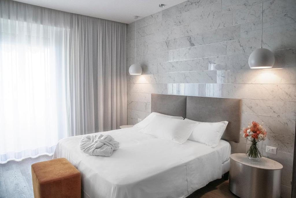 里米尼安必特全景酒店的卧室配有白色的床和砖墙