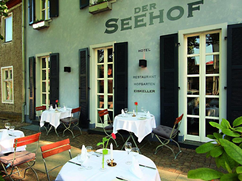 赖因斯贝格Der Seehof Rheinsberg的大楼前设有桌椅的餐厅