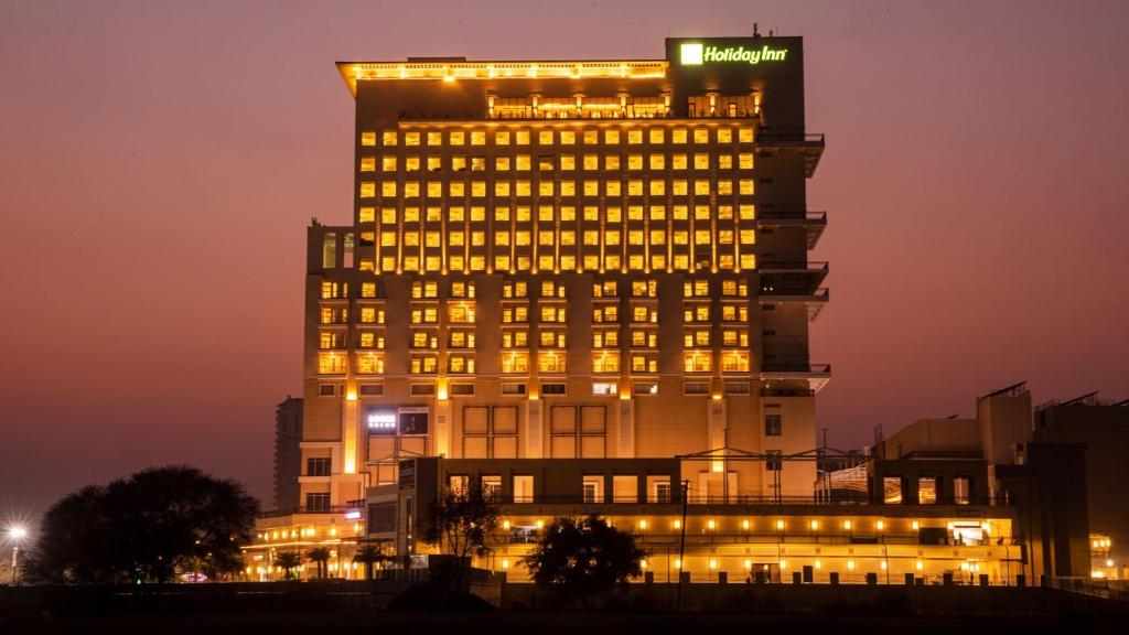 古尔冈Holiday Inn Gurugram Sector 90, an IHG Hotel的一座有灯的建筑,上面有标志