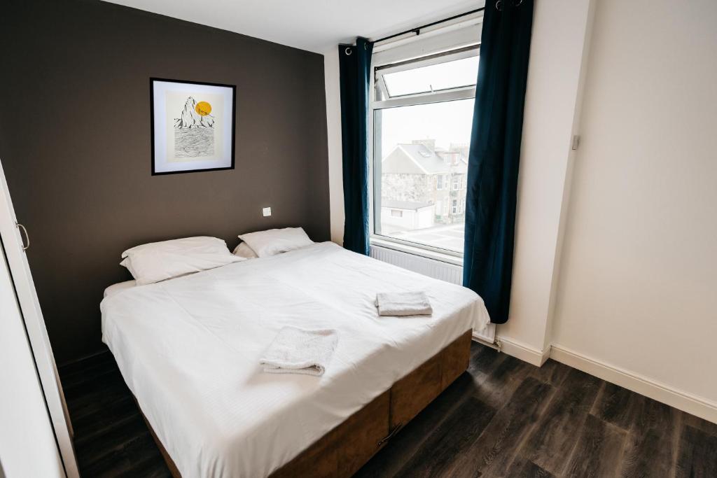 纽基Mordon Bar and Lodge的一间卧室配有一张带白色床单的床和一扇窗户。