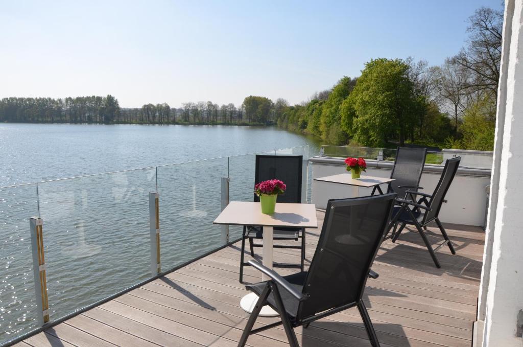 伊普尔Vijverhuis的水边甲板上的两张桌子和椅子