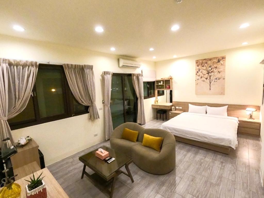 马公澎湖夏日南風民宿的酒店客房配有床、沙发和桌子。
